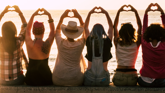 Girls sitting on the beach at sunset